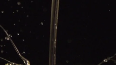 Liquid stream with splashes black background slow motion Stock Footage 55806790