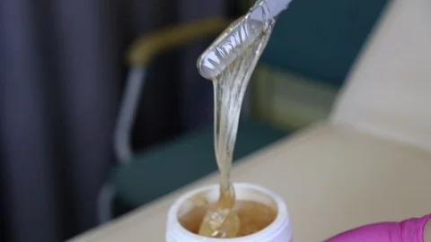 Liquid sugar for skin epilation. Close up shot. depilation and beauty concept - Stockbeeldmateriaal 125855461