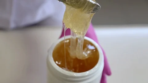 Liquid sugar for skin epilation. Close up shot. depilation and beauty concept - Stockbeeldmateriaal 125855490