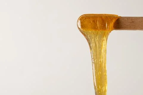 Liquid sugar wax on spatula with bubbles Stock Photos