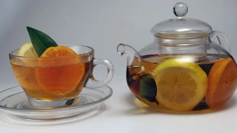 Liquid tea lemon orange slice green leaf cinnamon stick in transparent glass tea Stock Footage 144712333