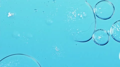 Liquid texture with burst drops on light blue background. Gel cosmetic with Stock Footage 204850572