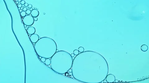 Liquid texture with burst drops on light blue background. Gel cosmetic with Stock Footage 238382192