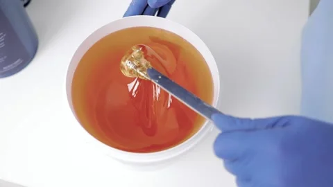 Liquid yellow sugar paste, close-up. Removal of unwanted hair. Stock Footage 239613487