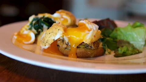 Liquid yolk Poached egg cut in half and runny yolk flow down on sandwich and Stock Footage 293339996