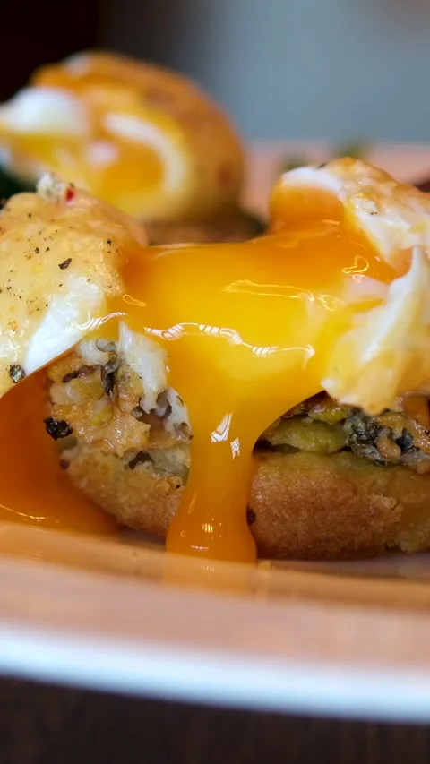 Liquid yolk Poached egg cut in half and runny yolk flow down on sandwich and Stock Footage 293973173