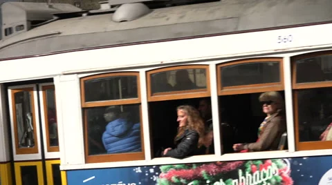 Lisbon Portugal Electric tram passes camera and proceeds down city streer Stock Footage 59592496