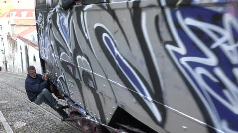 Lisbon Portugal Tram Passes the camera with a Freeloader hanging of the back. Stock Footage 59592588