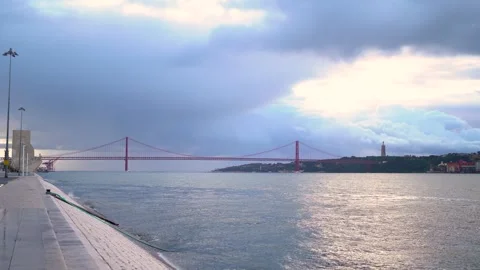 Lisbon red suspension bridge of 25th of April during sunrise on cloudy day Stock Footage 273674096
