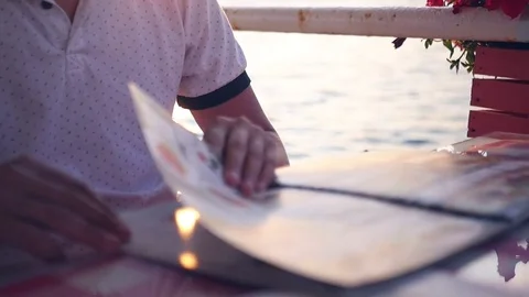 List the menu in the cafe in the evening at sunset. HD, 1920x1080. slow motion. Stock Footage 83343804