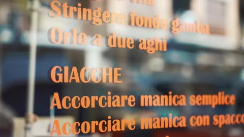 List of tailor services on atelier store window in Italian language with Stock Footage 247014608