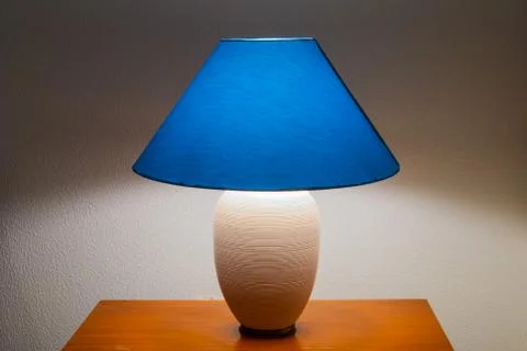Lit bedside lamp over nightstand Stock Photos