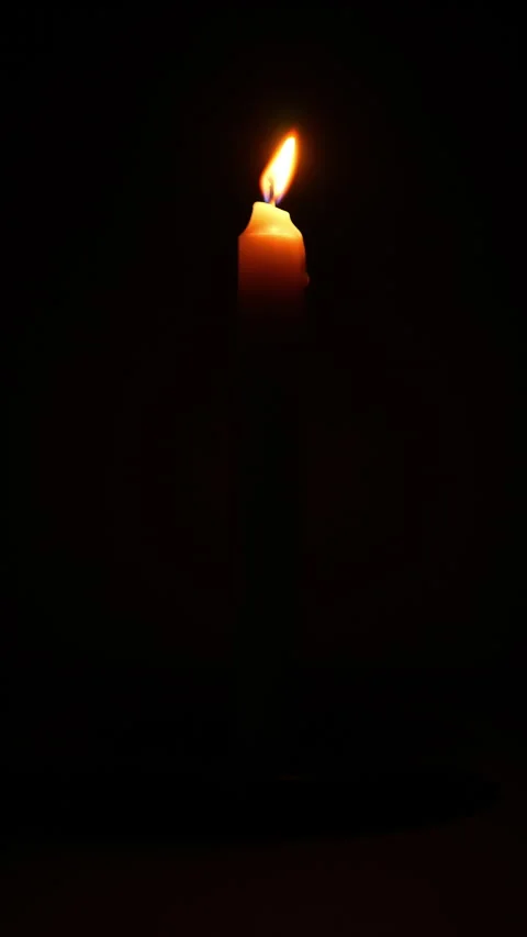 Lit candle on dark background vertical video. Close up single candle flame .. Stock Footage 344625492