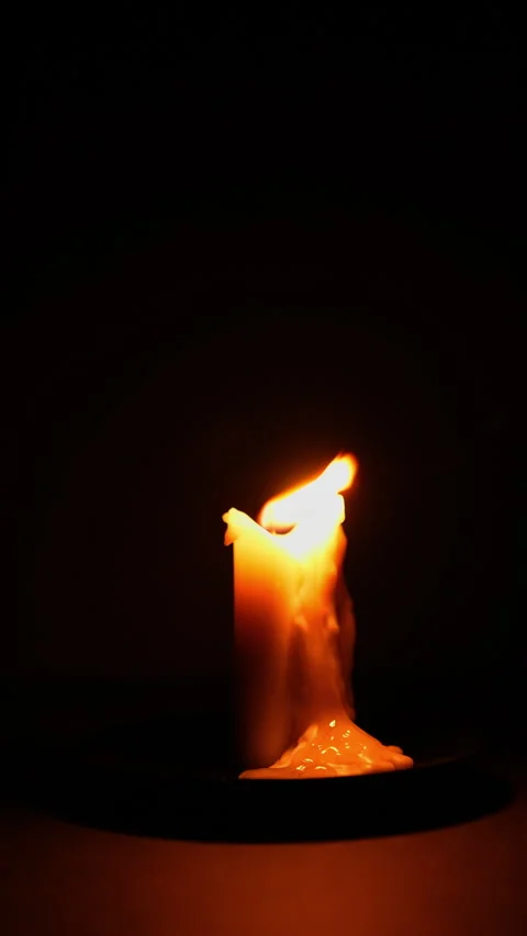 Lit candle on dark background vertical video. Close up single candle flame .. Stock Footage 344625540