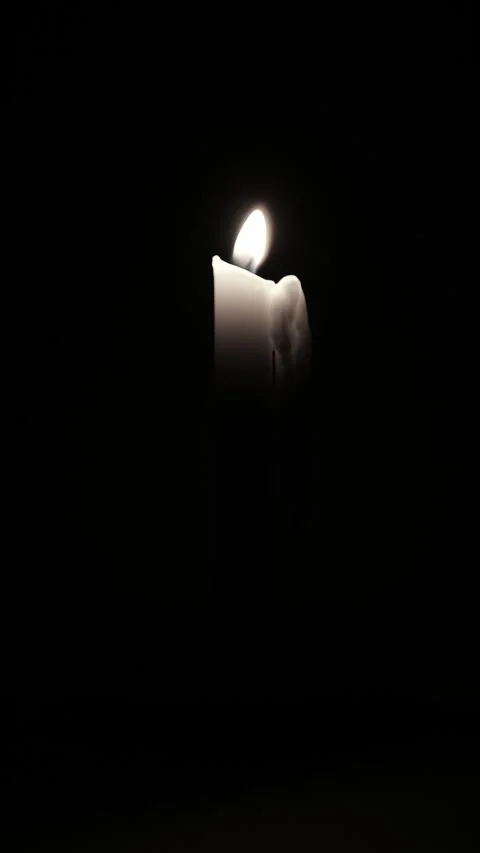 Lit candle on dark background vertical video. Close up single candle flame .. Stock Footage 344625637