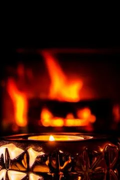 Lit candle with fireplace fired up Stock Photos