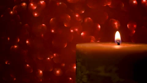 Lit candle on a red shimmering background Video stock 144949955