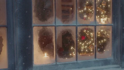 A lit christmas tree is visible through the snow frosted window panes Stock Footage 142863320