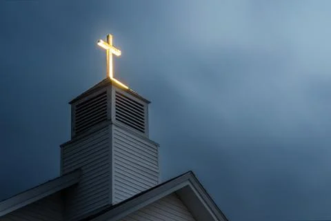 Lit Church Cross with Dramatic Clouds 库存照片