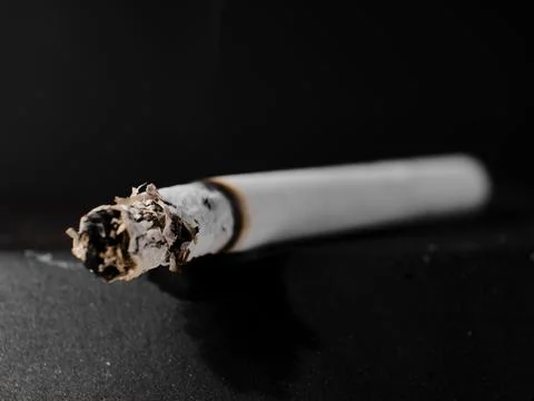 A lit cigarette in an ashtray Stock Photos