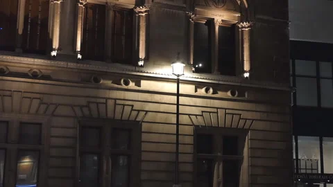 A lit up city lantern by an old stone building. Stock Footage 100088784