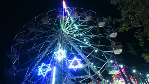 Lit Ferris Wheel with Star Decorations at Night 스톡 동영상 340278431