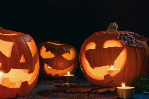 Lit jack o lantern pumpkins and candles create warm autumn night display wi.. Stock Photos