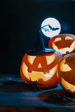 Lit Jack-O'-Lanterns With Witch Hat And Full Moon Stock Photos