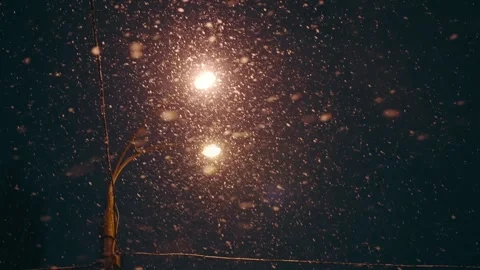 Lit lantern at night and falling snow on the street in winter Stock Footage 248264280