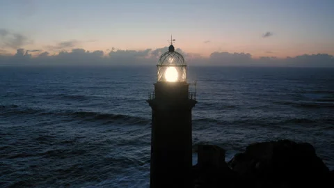 Lit lighthouse at dusk in Cape Vilan Galicia Spain Aerial view Stock Footage 151244587