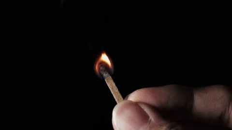 Lit match stick held in fingers burns through in 2.5x slow motion Stock Footage 117289069