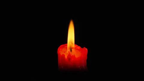 Lit red candle on black background. Stock Footage 303836131