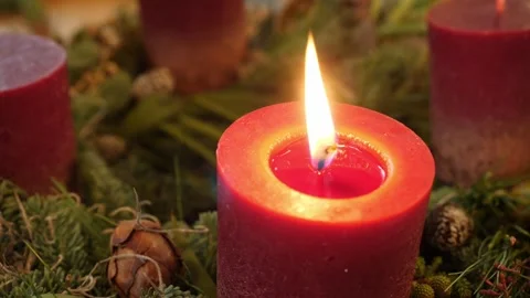 Lit red candle with pine cones and foliage, festive detail Stock Footage 319987415