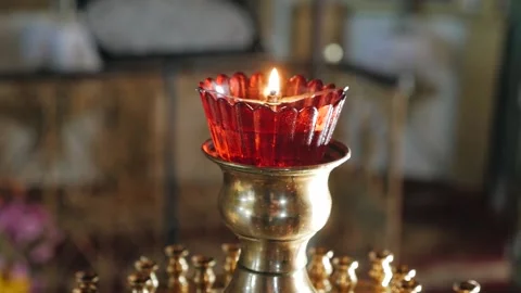 Lit red lamp in front of the icons in a shiny Golden candlestick on a blurred Video stock 147846010