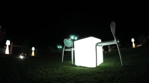 Lit table with two chairs in the garden Stockbeeldmateriaal 57816069