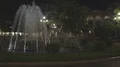 Lit up water jets shooting in air, park fountain at night, streetlamps around HD Footage