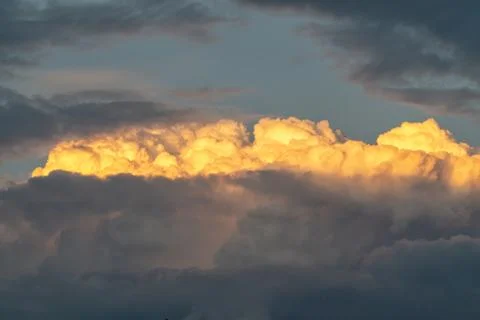 Lit yellow sunlight thundercloud at sunset Stock Photos