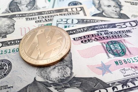 Litecoin coin on top of a stack of US dollars Stock Photos