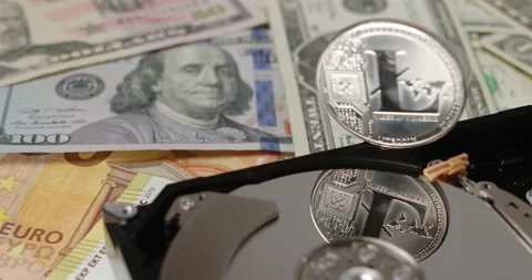 Litecoin on Dollar banknotes and Hard drive disk. Concept of crypto mining Stock Footage 154055409