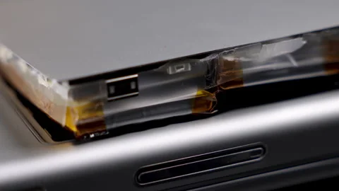 Lithium ion battery damaged macro close up. Defective battery fire hazard. Stock Footage 263988250