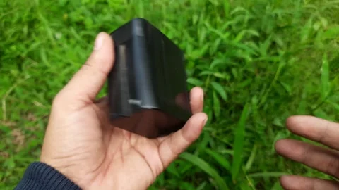 Lithium Multifunction Battery Held Against Green Grass Stock Footage 296413311