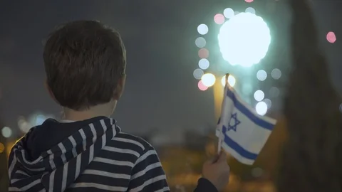 Litle boy looking at fireworks and Waving Israeli Flag, 스톡 동영상 108080373