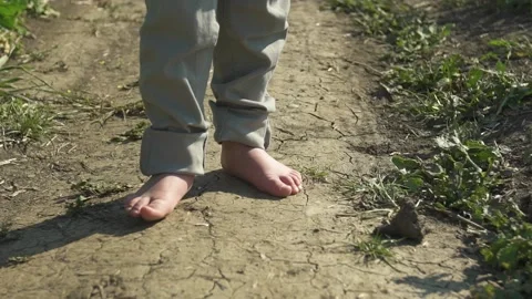 Litle boy, walks barefoot on the path Stock Footage 130873944