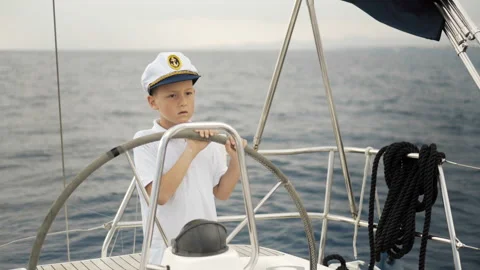 Litle children skipper at the helm controls of a sailing yacht during race. Stock Footage 92003464