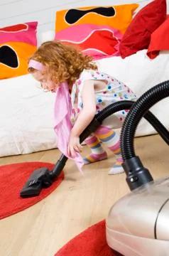 Littel girl with vacuum cleaner Stock Photos