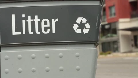 Litter caption writing and recycle symbol on garbage with blurred traffic Stock-Footage 246611067