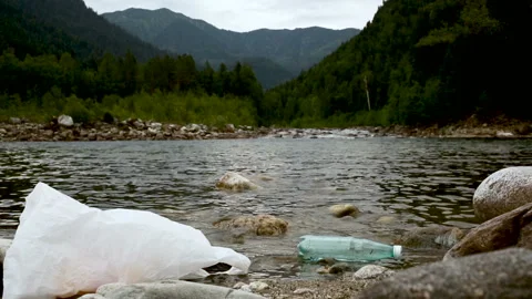 Litter trash in river streaming in forest. iroi garbage bottle and bag waste Stock-Footage 134849015