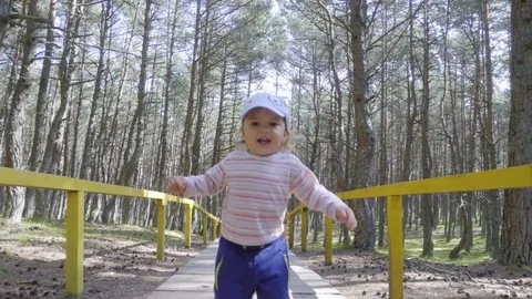 Little 2 year old baby boy is walking on forest. Child make his first steps o Stock Footage