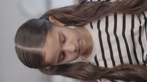 Little 6 years old long haired sweet girl sitting on sofa is feeling shy. Stock Footage 152017953