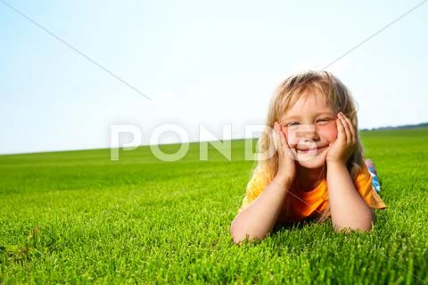 Little adorable girl lying on grass Stock Photos